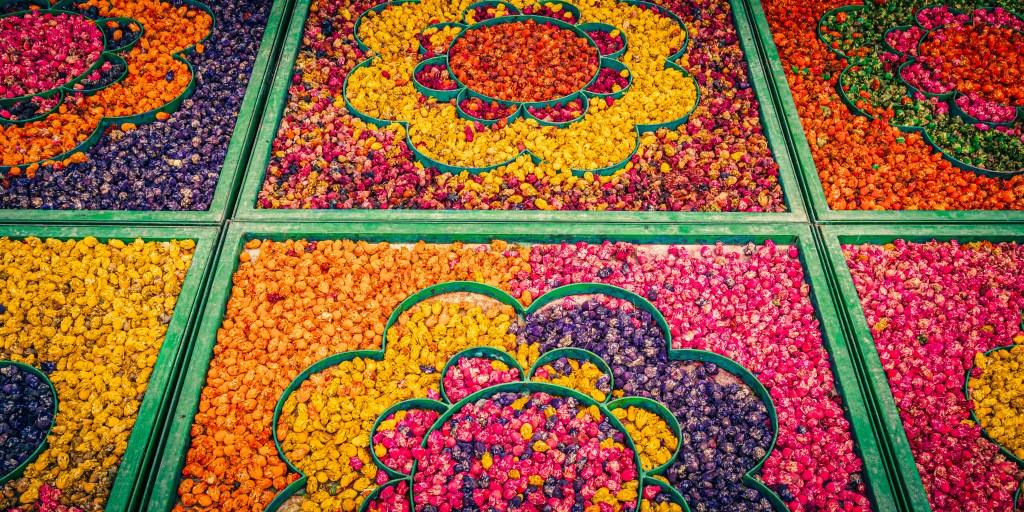 Colorful arrangement of flower petals in various shapes and patterns, featuring vibrant hues of orange, pink, purple, and yellow.
