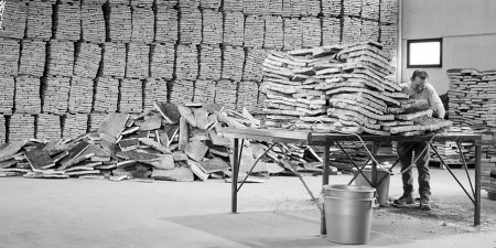 An artisan busy at work cutting cork barks.